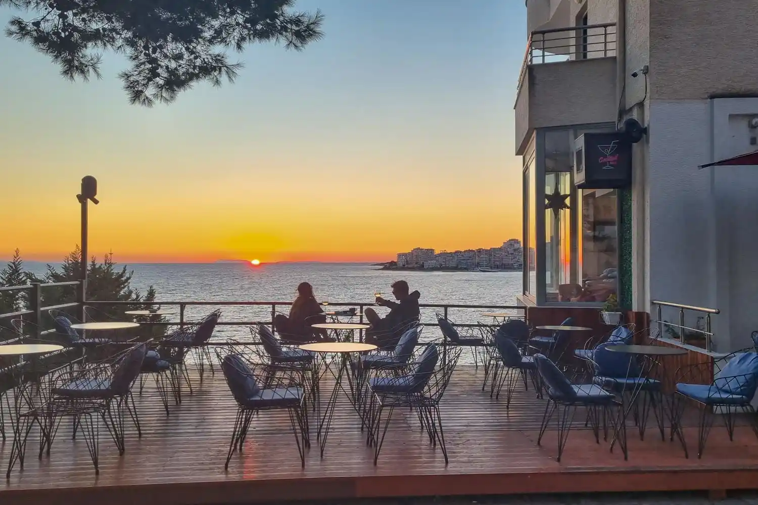 Seafront café terrace at sunset in Saranda, with views across the Ionian Sea